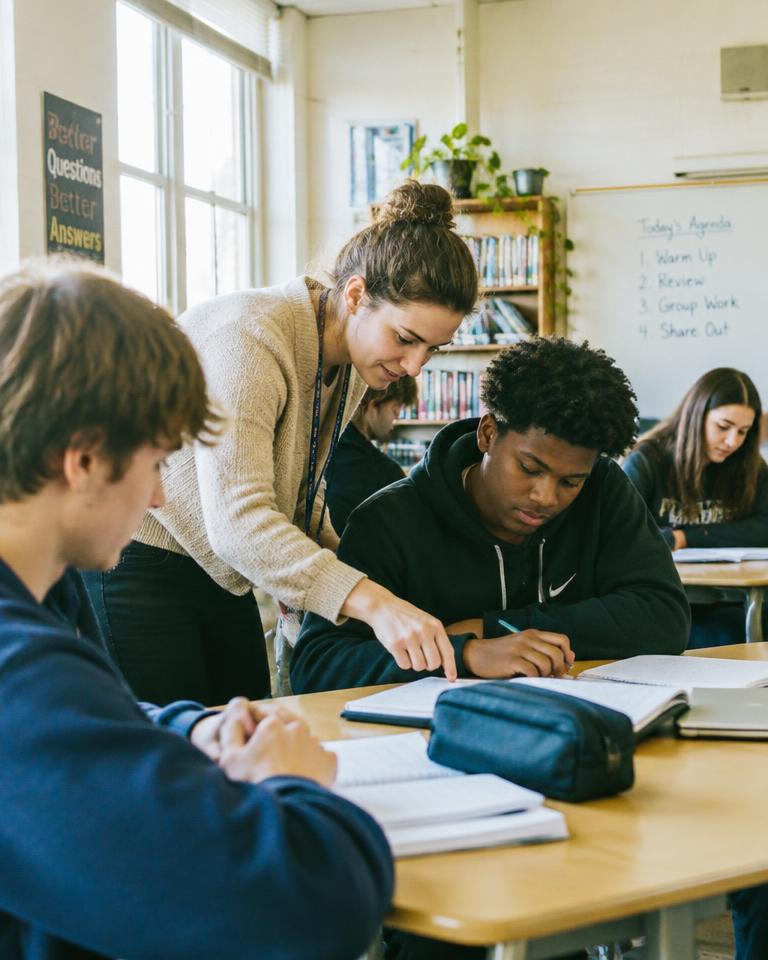 A teacher helping students in a classroom